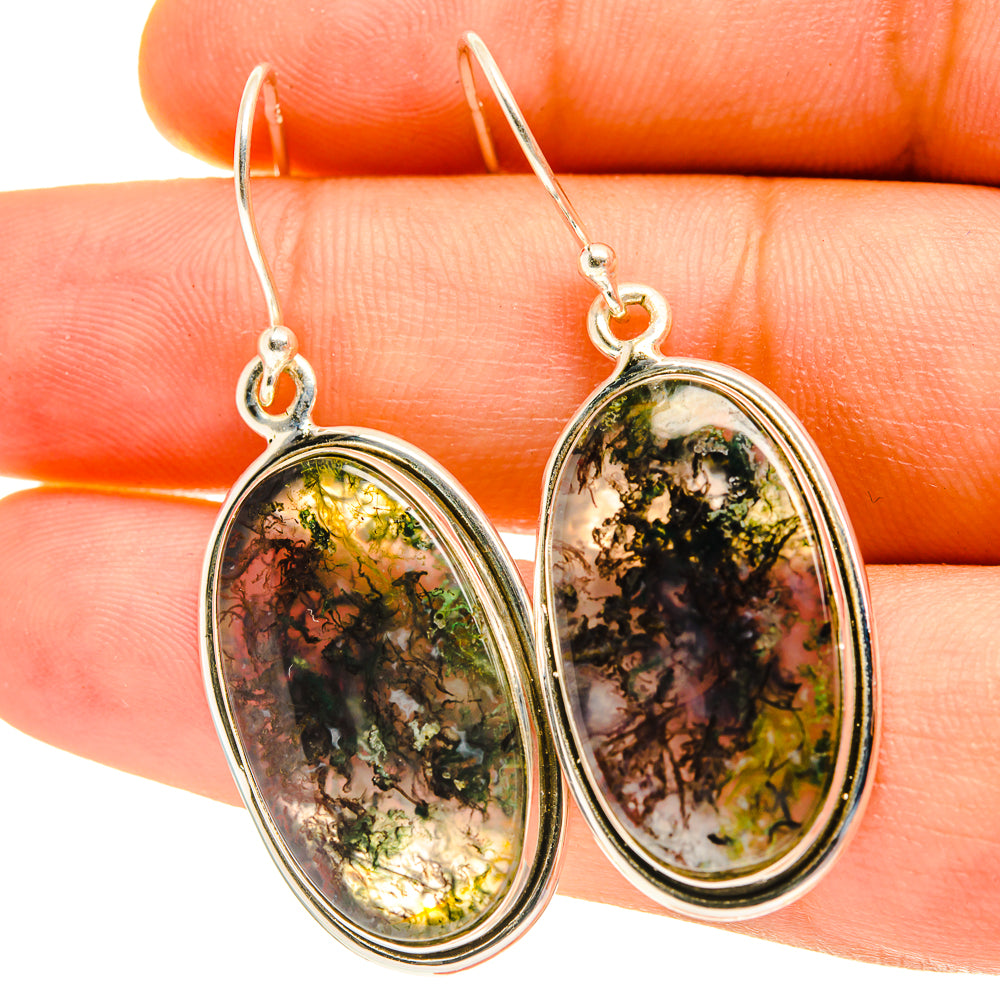 Close-up oval moss agate drop earrings, green-gold mottled stones in silver bezels