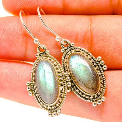 Oval labradorite cabochon drop earrings with ornate bezel and silver hooks
