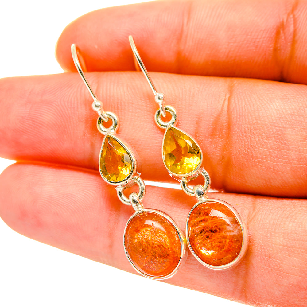 Silver-tone drop earrings with yellow teardrop and orange round gemstones, lever hooks.