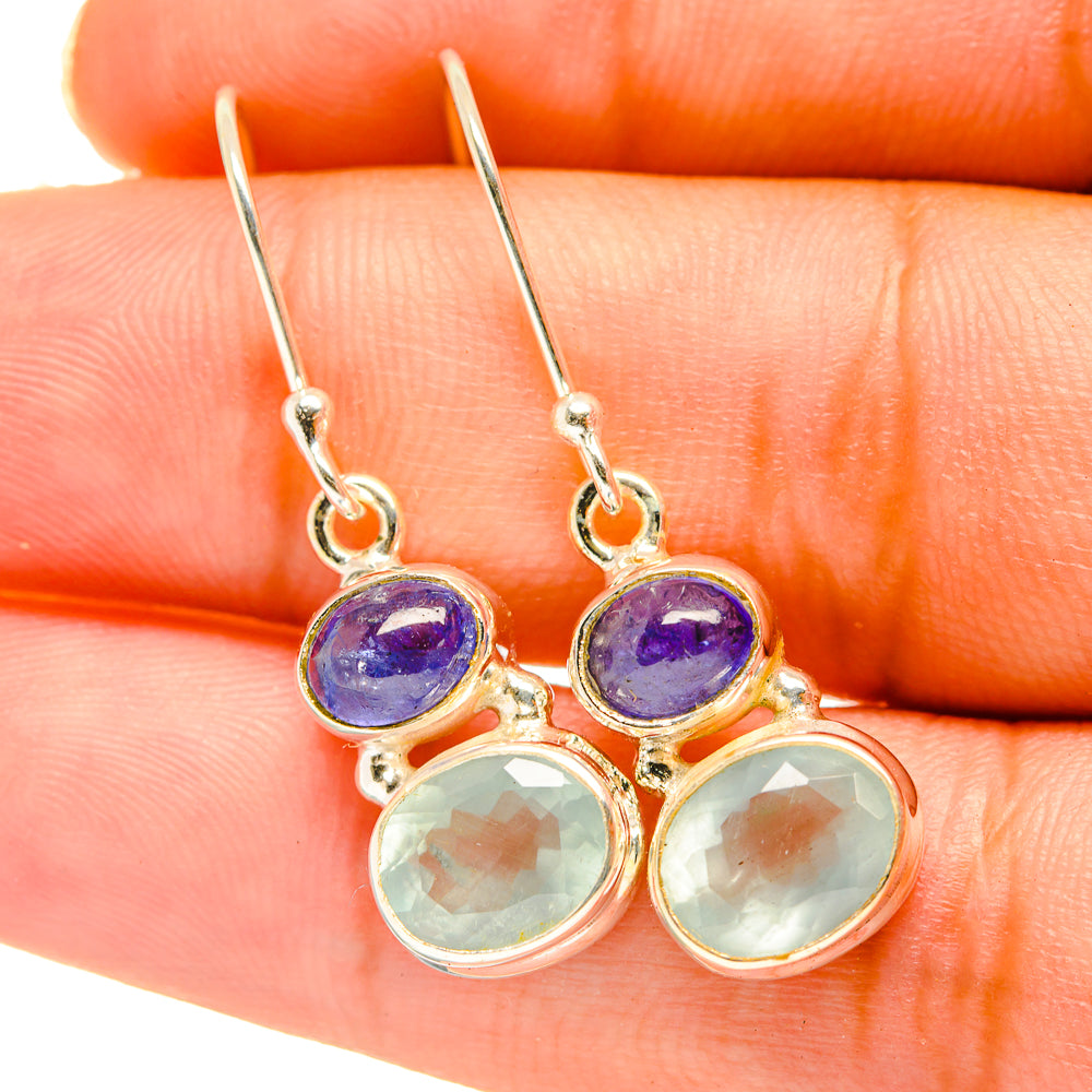 Dangling silver-tone earrings with purple and pale green round gemstones