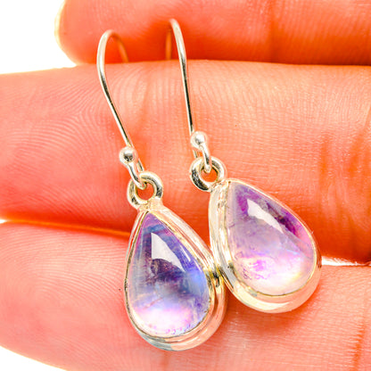 Close-up teardrop moonstone earrings with purple iridescent stones and silver hooks