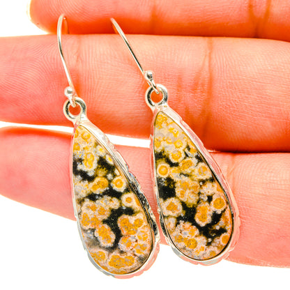 Ocean jasper teardrop earrings in silver setting, close-up of orange, yellow, and black pattern