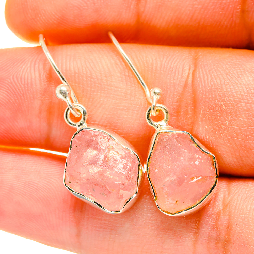 Close-up rough pink rose quartz earrings with silver lever hooks and textured stones