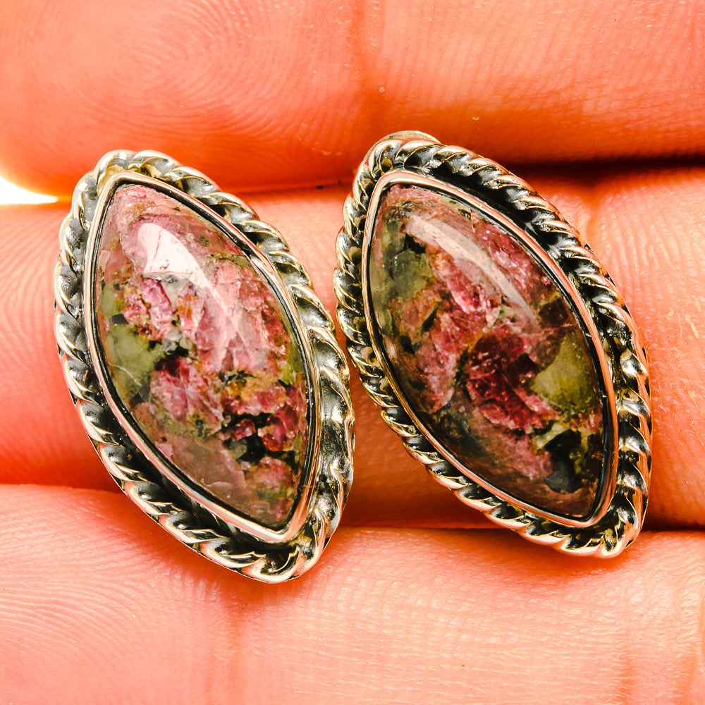 Oval eudialyte earrings with detailed silver-tone bezel and speckled red-green stone