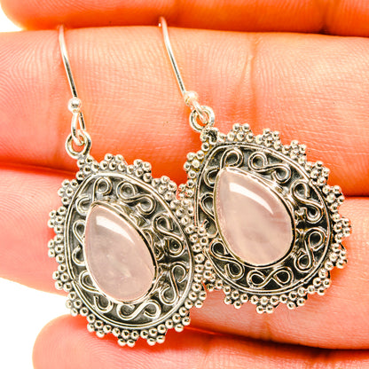 Rose quartz teardrop earrings with ornate filigree frames and drop hooks