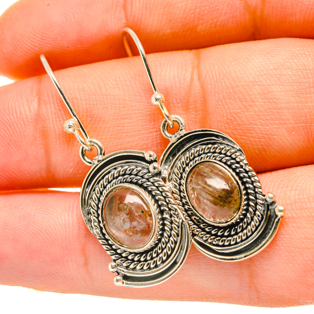 Oval rutilated quartz earrings with ornate silver-tone frames and dangling hooks