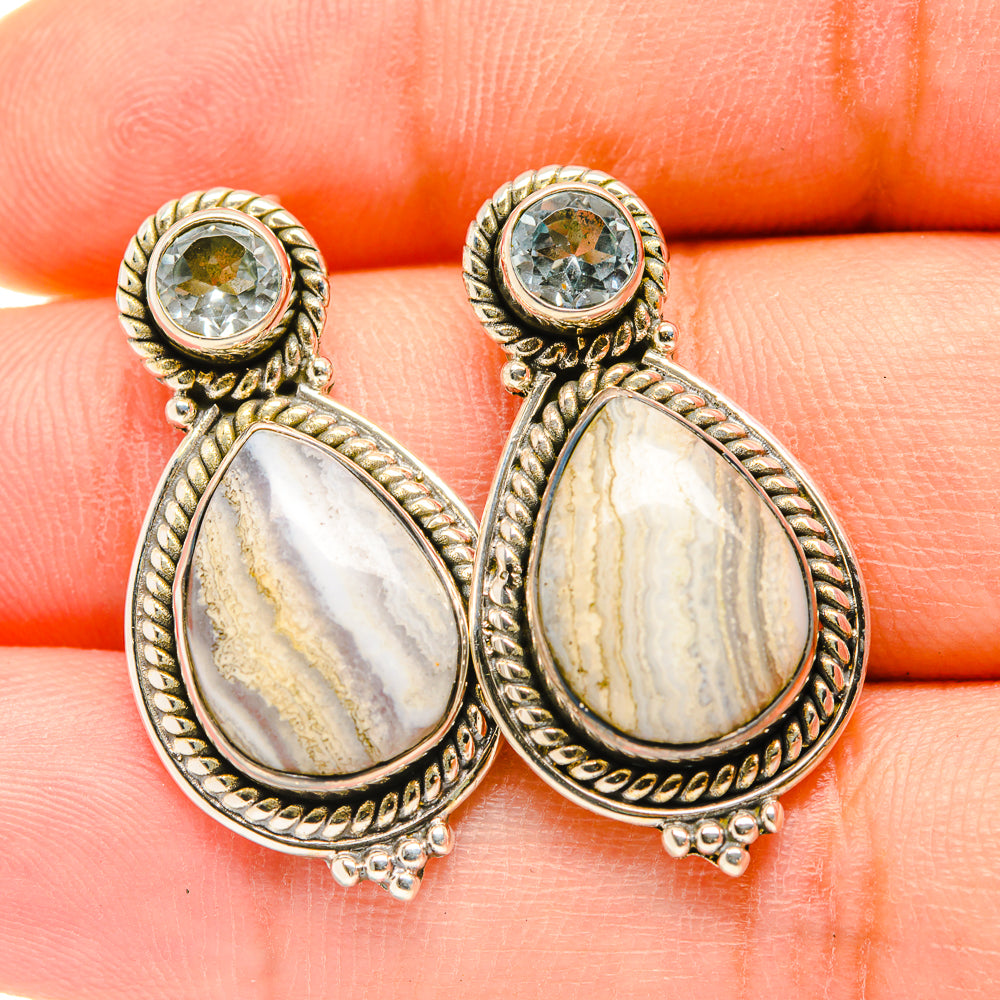 Ornate gold teardrop earrings with round blue stone cap and white oval pendant