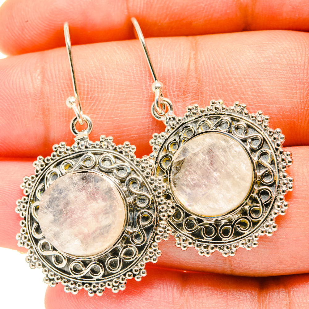 Round moonstone cabochon dangle earrings with ornate silver-tone filigree halo