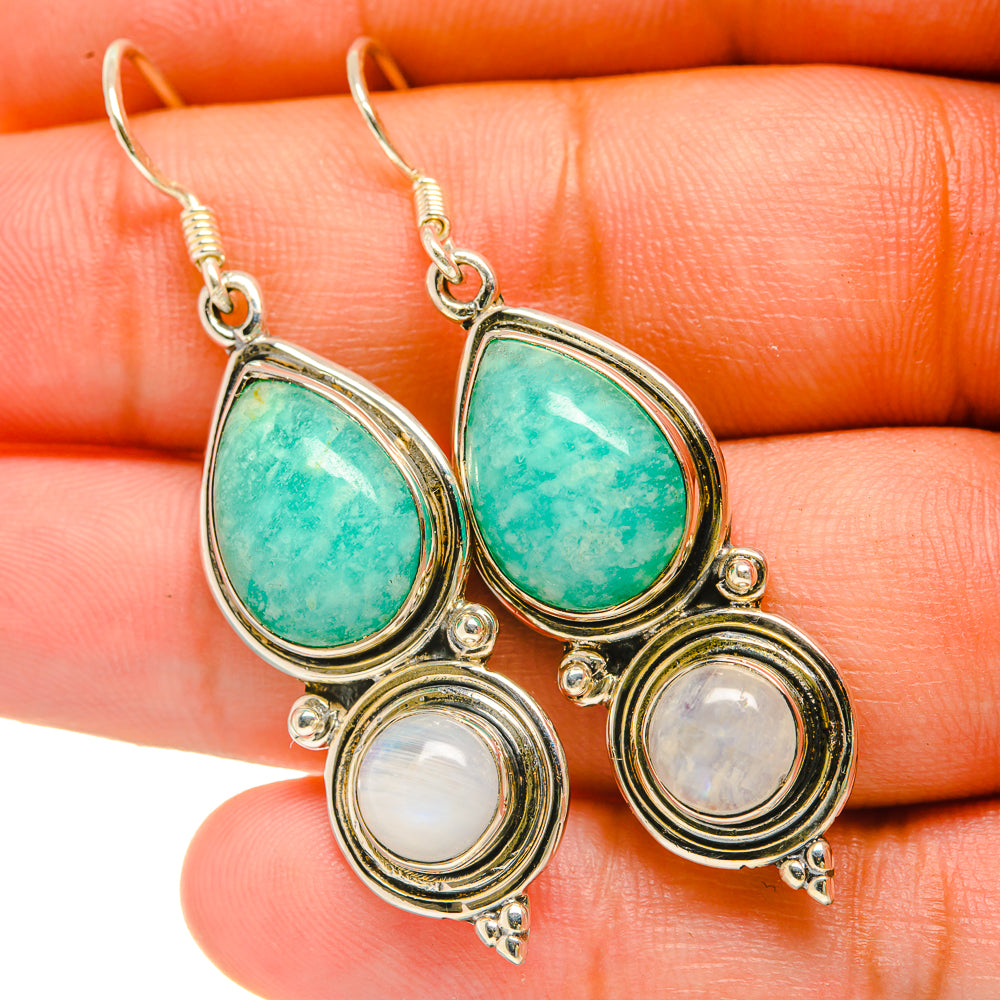 Teardrop earrings close-up with green stones, round white accents, silver 925 hooks