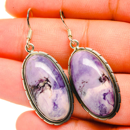Pair of oval purple stone drop earrings with silver hooks and bezel settings