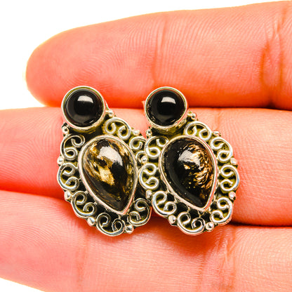 Ornate filigree earrings with black onyx cabochon ovals and round stones in gold-tone frames