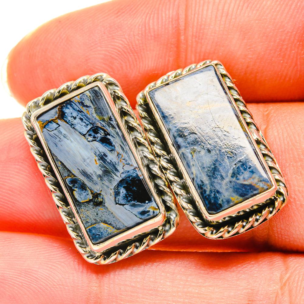 Close-up rectangular blue pietersite stud earrings in ornate braided frame