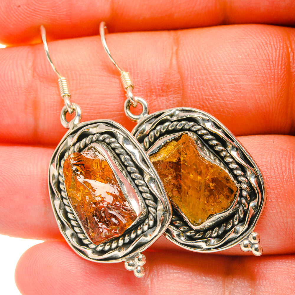 Rough citrine drop earrings with faceted orange-gold stone in silver braided oval setting
