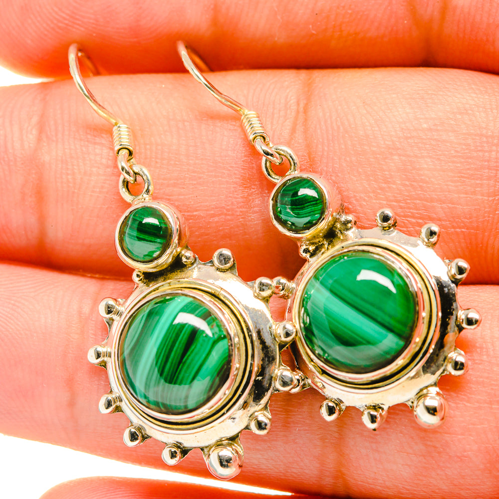 Close-up of round green malachite drop earrings with studded bezel and hook