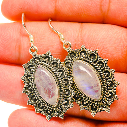 Iridescent oval gemstone earrings with ornate silver-tone filigree and fishhook drops