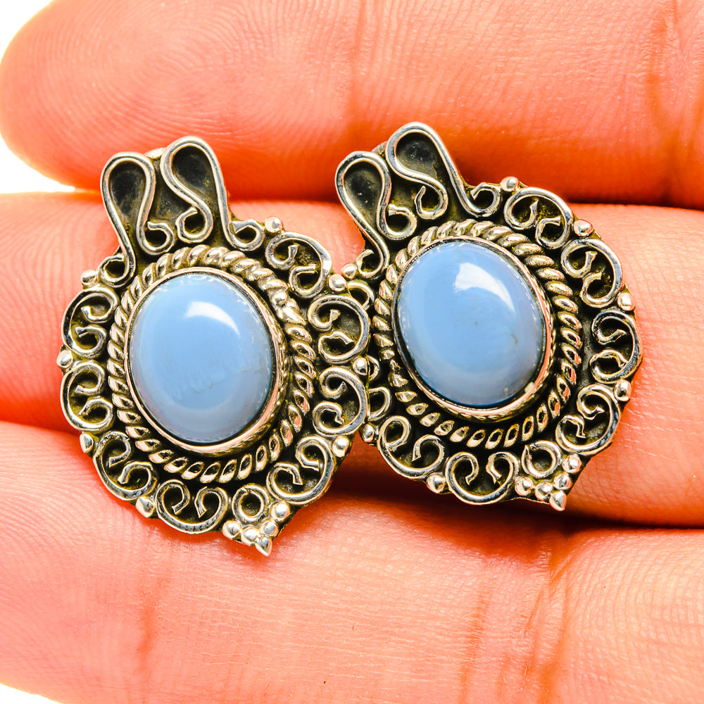 Blue opal stud earrings with round cabochon, gold filigree border and dark accents