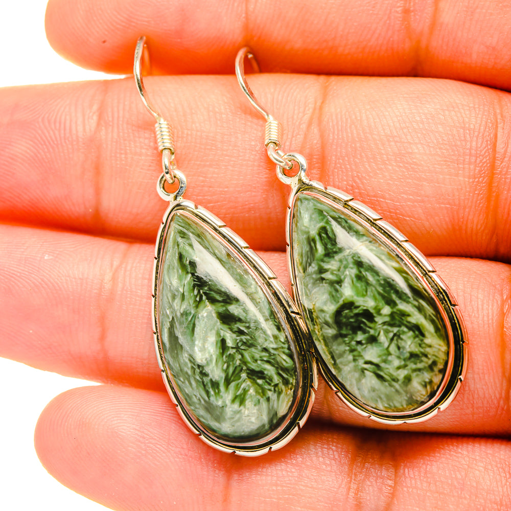Close-up of green seraphinite teardrop dangle earrings with sterling silver hooks