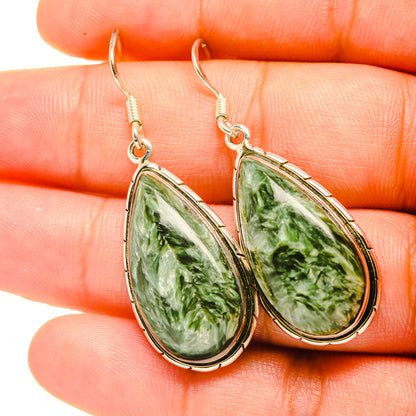 Close-up of green seraphinite teardrop dangle earrings with sterling silver hooks