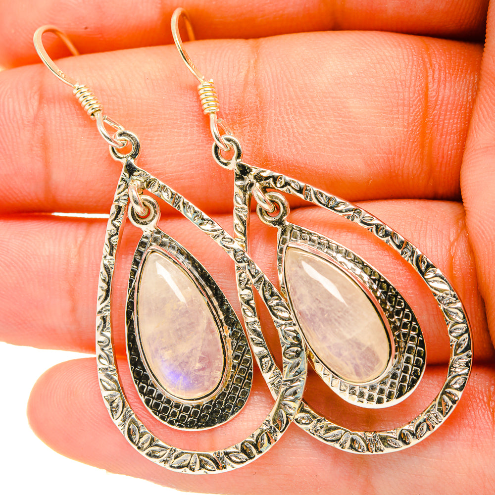 Teardrop drop earrings with pearly iridescent oval center, textured silver-toned metal hooks