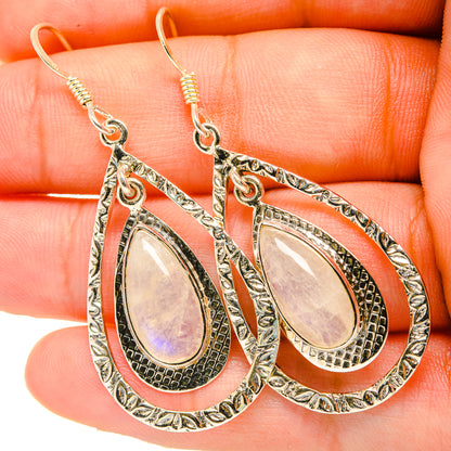 Teardrop drop earrings with pearly iridescent oval center, textured silver-toned metal hooks