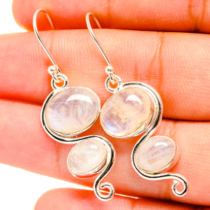 Sterling silver moonstone drop earrings with four oval opalescent stones in swirl frames