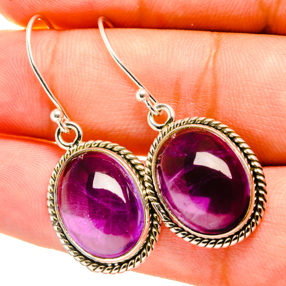 Close-up of 925 sterling silver oval amethyst drop earrings with rope bezel and hook backs