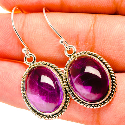 Close-up of 925 sterling silver oval amethyst drop earrings with rope bezel and hook backs