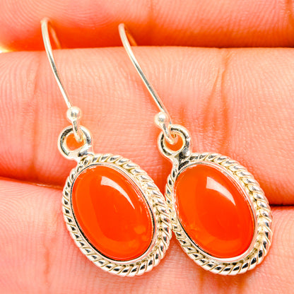 Silver carnelian drop earrings with oval orange gemstones and ornate halo settings