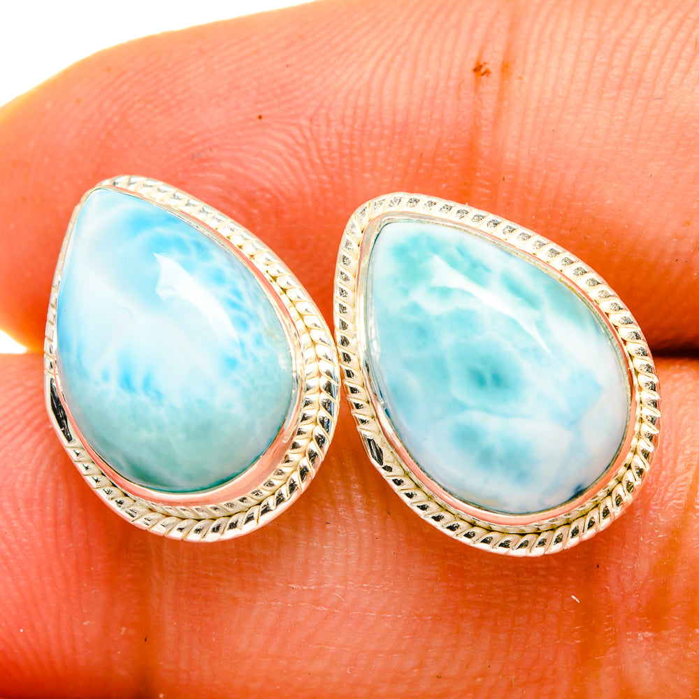 Larimar teardrop earrings with oval blue stone and silver textured bezel, close-up