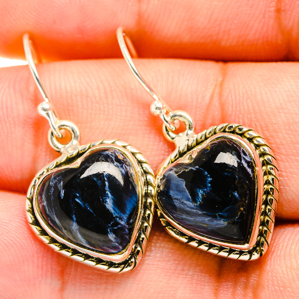 Close-up of blue heart pietersite in 925 sterling silver drop earrings with textured border