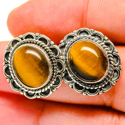 Tiger eye stud earrings, close-up of round golden-brown cabochons in detailed silver bezels