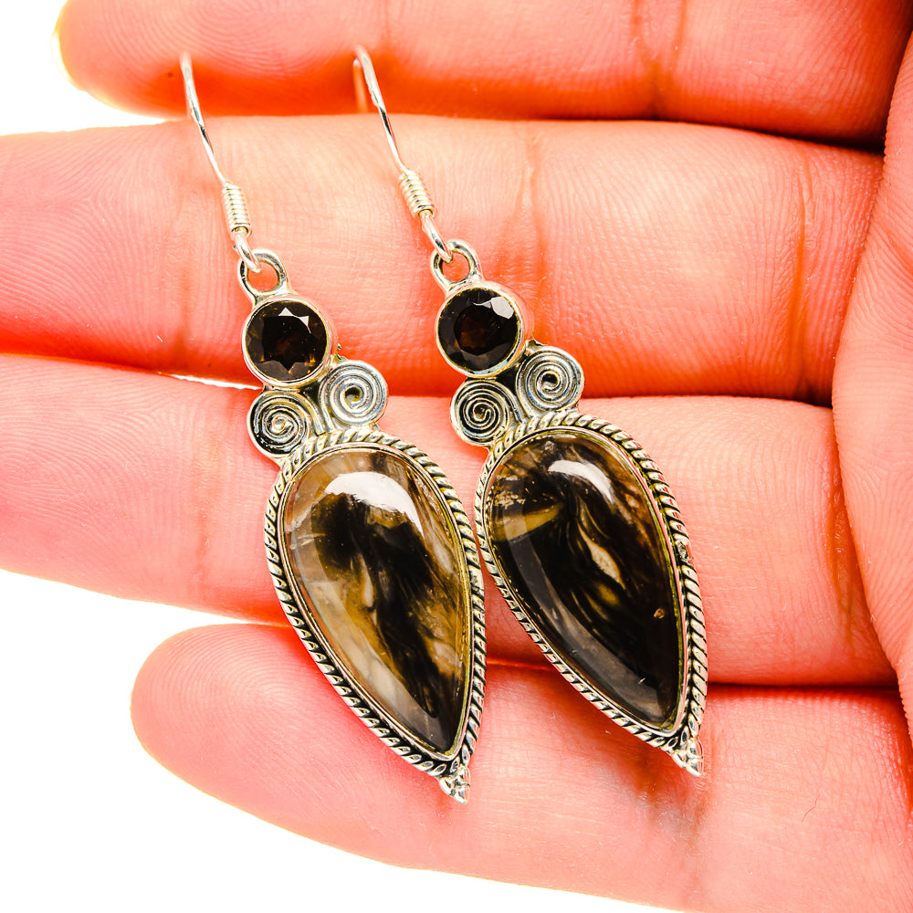 Silver dangle earrings with dark round top accents and amber teardrop cabochons