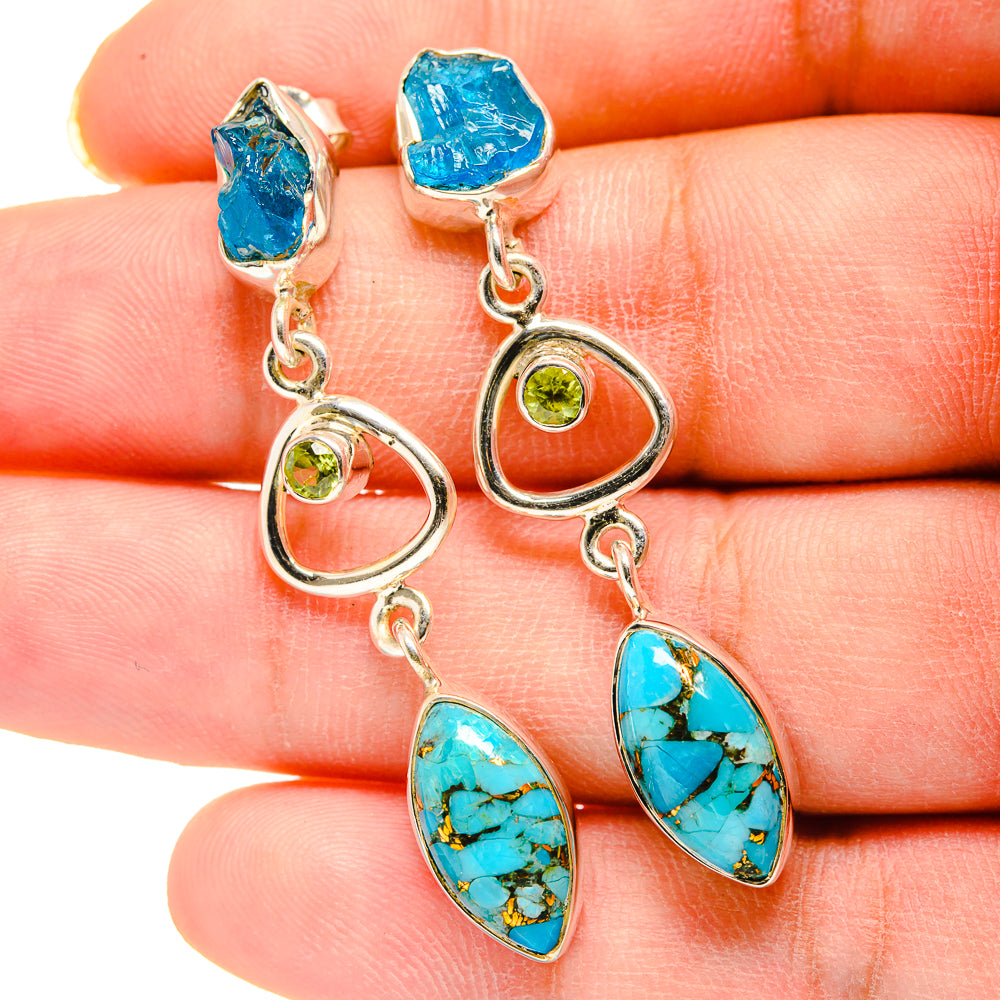 Drop earrings on fingers: blue and turquoise ovals with green round stones, silver hooks and links