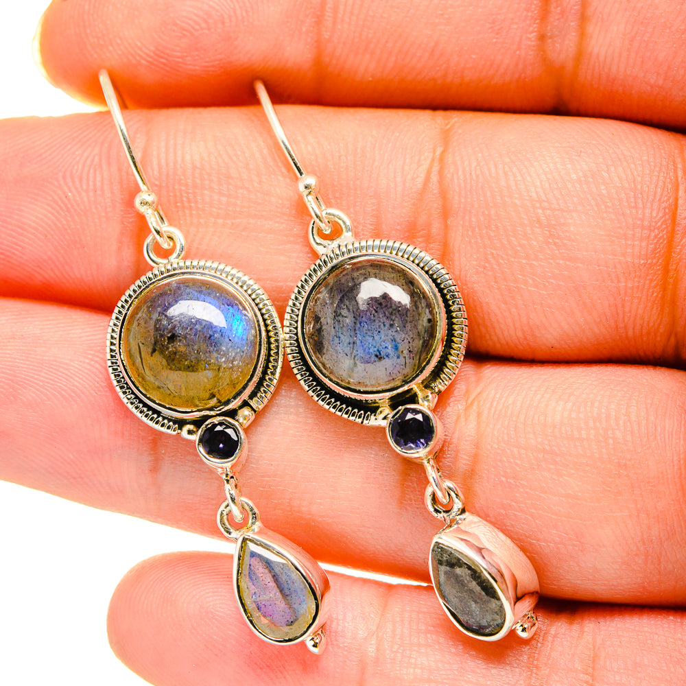 Closeup of 925 silver drop earrings with round labradorite, dark onyx, and teardrop dangles