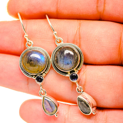 Closeup of 925 silver drop earrings with round labradorite, dark onyx, and teardrop dangles