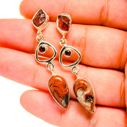 Silver-tone dangle earrings with orange-brown marbled teardrop stones and red accents