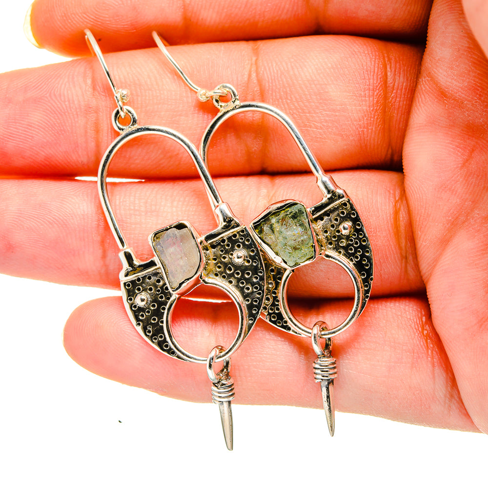 Gold-tone hoop earrings with rough aquamarine-colored stones, textured bezels, and spikes