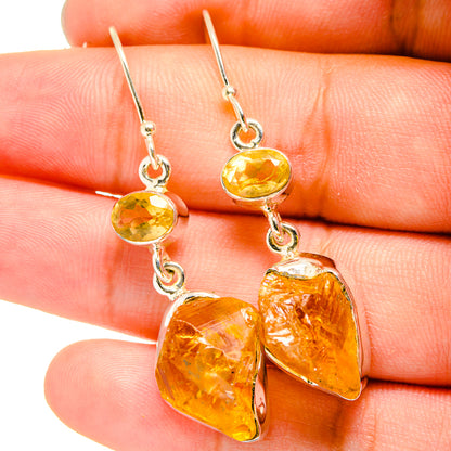 Rough citrine earrings close-up: amber-yellow faceted drops on silver hooks