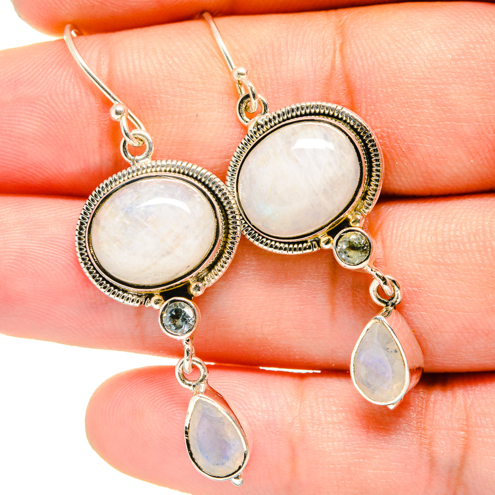 Sterling silver drop earrings with bezel-set opalescent ovals and blue topaz dangles