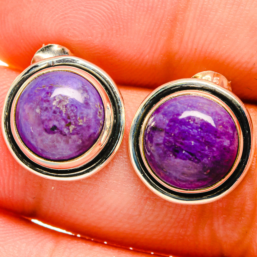 Close-up round sterling silver earrings with purple cabochon gemstone bezel
