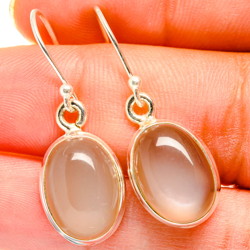 Oval moonstone drop earrings with sterling-silver frames and dangling hoops, peachy glow
