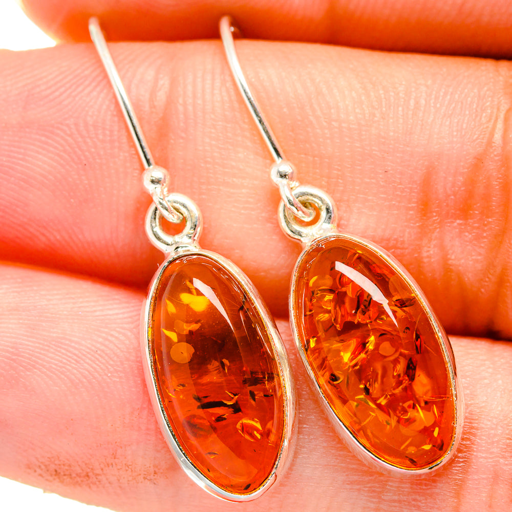 Amber oval dangle earrings with sterling silver hooks and faceted orange Baltic amber