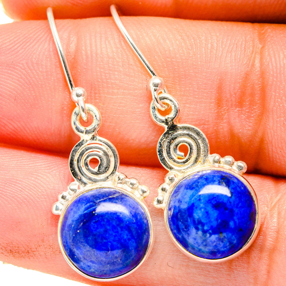 Close-up of 925 sterling silver drop earrings with round blue lapis stones and dangle hoops