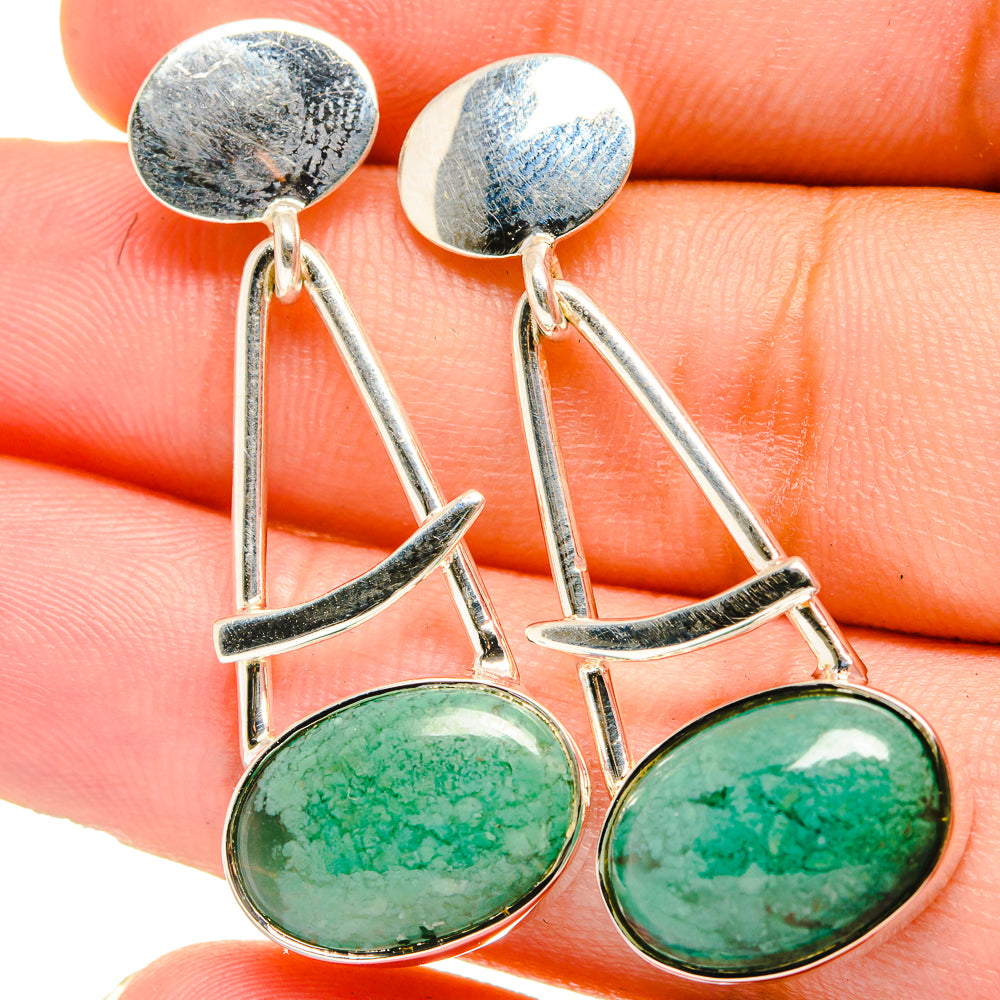 Sterling silver earrings with green oval cabochons and hanging curved geometric frames