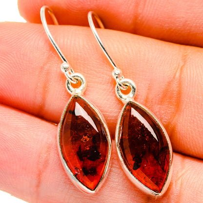 Amber teardrop dangle earrings with silver hooks and dark red-brown stone