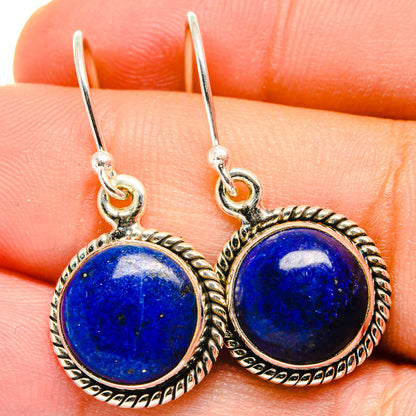 Close-up of round lapis lazuli earrings with ornate silver bezel and hook closure