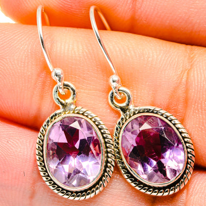 Closeup of round faceted amethyst earrings, 925 sterling silver hooks and bezel