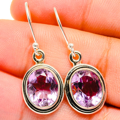 Faceted amethyst drop earrings with circular gold-tone frame and teardrop hooks