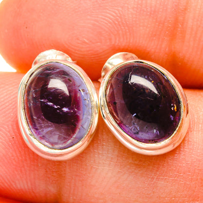Oval purple tanzanite gemstone stud earrings in sterling silver bezel, close-up