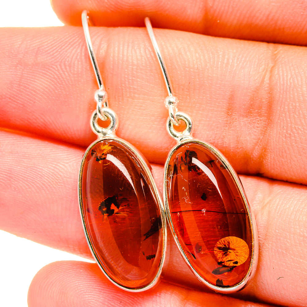 Oval amber drop earrings in silver settings with dangling hooks